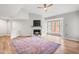 Vaulted living room with hardwood floors, a fireplace, a television, and a large area rug at 1061 Wirewood Dr # 303, Raleigh, NC 27605