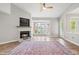Light-filled living room features fireplace, a ceiling fan, hardwood floors, and a large bay window at 1061 Wirewood Dr # 303, Raleigh, NC 27605