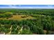 Expansive aerial view of the property showcasing lush greenery, open fields, and surrounding neighborhood at 1128 Neuse Ridge Dr, Clayton, NC 27527