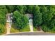 Aerial view of a charming two-story home with lush green trees and a long driveway at 1128 Neuse Ridge Dr, Clayton, NC 27527