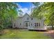 Back exterior view of home with a deck, fenced yard, and mature trees, creating a private outdoor space at 1128 Neuse Ridge Dr, Clayton, NC 27527