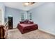 Cozy bedroom featuring light blue walls, neutral carpet, and a burgundy bed beneath a ceiling fan at 1128 Neuse Ridge Dr, Clayton, NC 27527