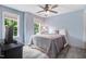 Inviting bedroom with hardwood floors, natural light, ceiling fan, and a comfortable bed with patterned bedding at 1128 Neuse Ridge Dr, Clayton, NC 27527
