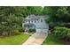 Charming two-story home with a light blue exterior, two-car garage, and a welcoming front porch at 1128 Neuse Ridge Dr, Clayton, NC 27527