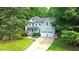 Charming two-story home with a well-manicured lawn, a two-car garage, and lush, mature landscaping at 1128 Neuse Ridge Dr, Clayton, NC 27527