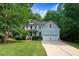 Inviting two-story home featuring a covered porch, a two-car garage, and a beautifully landscaped front yard at 1128 Neuse Ridge Dr, Clayton, NC 27527
