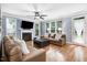 Inviting living room with a fireplace, hardwood floors, and abundant natural light at 1128 Neuse Ridge Dr, Clayton, NC 27527