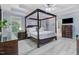 Spacious main bedroom with a four-poster bed, tray ceiling, and ensuite bath at 1128 Neuse Ridge Dr, Clayton, NC 27527