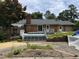 Backyard showcasing a brick house with a wooden deck and a sprawling lawn at 1208 Hatch Rd, Chapel Hill, NC 27516