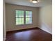 Bright bedroom featuring new paint, a large window, and wood-look flooring at 1208 Hatch Rd, Chapel Hill, NC 27516