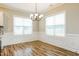 Well-lit dining room featuring wood floors, decorative wall trim, and a modern chandelier creating an elegant atmosphere at 123 Pleasant View Ln, Benson, NC 27504