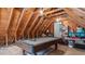 Spacious attic with exposed wooden beams, a pool table, and storage at 1401 Berea Rd, Rougemont, NC 27572
