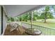 Spacious porch features wood flooring and white railings with seating and wooded views at 1401 Berea Rd, Rougemont, NC 27572