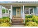 Inviting front porch with yellow door, bench, and flowerpots on a wood deck at 1448 Big Falls Dr, Wendell, NC 27591