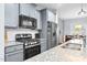 Close-up of a modern kitchen with granite countertops, stainless steel appliances, and stylish cabinetry at 1448 Big Falls Dr, Wendell, NC 27591