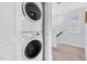Modern stacked washer and dryer in a convenient laundry area with stylish light fixture at 1448 Big Falls Dr, Wendell, NC 27591