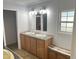 Bathroom featuring double sinks, wood cabinets, and modern lighting fixtures at 145 Country Walk Ln, Sanford, NC 27332