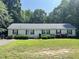 Charming single story home with a well maintained lawn, mature trees, and lovely landscaping at 145 Country Walk Ln, Sanford, NC 27332