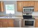 Kitchen with stainless steel appliances, double sink, and wood cabinetry at 145 Country Walk Ln, Sanford, NC 27332