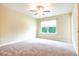 Light-filled bedroom boasts neutral carpet, a ceiling fan, and a large window at 145 Torrey Heights Ln, Durham, NC 27703