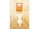 Close-up of toilet and cabinet with wooden doors in cozy half-bath at 145 Torrey Heights Ln, Durham, NC 27703
