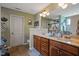 Bathroom featuring a dual sink vanity and a mirrored wall, plus a partitioned toilet at 15 Scuppernong Ln, Lillington, NC 27546