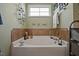 Bathroom featuring a large soaking tub, tile accents, and a window for natural light, creating a relaxing space at 15 Scuppernong Ln, Lillington, NC 27546