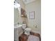 A half bathroom featuring a pedestal sink, toilet, a mirror, and a decorative shelf at 15 Scuppernong Ln, Lillington, NC 27546