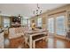 Open dining room featuring hardwood floors, a rustic table, and a view into the comfortable living area at 15 Scuppernong Ln, Lillington, NC 27546