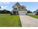 Charming two-story home with a well-manicured lawn and a two-car garage on a sunny day at 15 Scuppernong Ln, Lillington, NC 27546