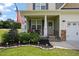 Welcoming front porch featuring charming decor, complemented by lush landscaping and well-maintained lawn at 15 Scuppernong Ln, Lillington, NC 27546