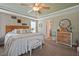 Cozy bedroom with a tray ceiling, ceiling fan, and coordinated decor and bedding creating a comfortable retreat at 15 Scuppernong Ln, Lillington, NC 27546