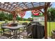 Outdoor patio beneath the pergola with seating, a grill, and decorative accents at 15 Scuppernong Ln, Lillington, NC 27546