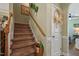Carpeted staircase with a wooden handrail and a decorative wreath on the wall and a glimpse into the living room at 15 Scuppernong Ln, Lillington, NC 27546