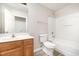 Full bath with a wood vanity and a tub and shower with a white surround, toilet, and large mirror at 1527 Haywards Heath Ln, Apex, NC 27502