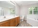 Bathroom featuring dual sinks, a soaking tub, separate shower, and natural light from the windows at 1527 Haywards Heath Ln, Apex, NC 27502