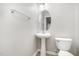A half bathroom featuring a pedestal sink, a toilet, and modern fixtures at 1527 Haywards Heath Ln, Apex, NC 27502