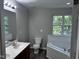 Bright bathroom featuring a large vanity, toilet, and tub with tile surround at 1527 Haywards Heath Ln, Apex, NC 27502