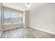 Well-lit bedroom with light gray plank flooring and large window view of a second home at 1527 Haywards Heath Ln, Apex, NC 27502