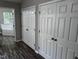 Bedroom with hardwood floors, white closet doors, and ensuite bathroom with tub at 1527 Haywards Heath Ln, Apex, NC 27502