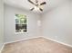 A bright bedroom featuring a window, neutral carpet, and a ceiling fan at 1527 Haywards Heath Ln, Apex, NC 27502