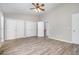 Spacious bedroom with wood-look floors, a ceiling fan, and multiple closets for storage at 1527 Haywards Heath Ln, Apex, NC 27502