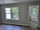 Bedroom with hardwood floors, neutral paint, and ensuite bathroom with tub at 1527 Haywards Heath Ln, Apex, NC 27502