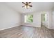 Bedroom with wood-look floors, a ceiling fan, and a large window for natural light at 1527 Haywards Heath Ln, Apex, NC 27502