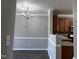 Dining room with modern light fixture and view into adjacent kitchen at 1527 Haywards Heath Ln, Apex, NC 27502
