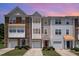 Three-story townhomes with varied facades, attached garages, and manicured front lawns create a welcoming curb appeal at 1527 Haywards Heath Ln, Apex, NC 27502