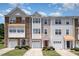 Three-story townhomes with varied facades, attached garages, and manicured front lawns create a welcoming curb appeal at 1527 Haywards Heath Ln, Apex, NC 27502
