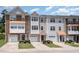 Street view of modern townhomes featuring brick accents, well-manicured lawns, and attached garages at 1527 Haywards Heath Ln, Apex, NC 27502