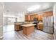 Eat-in kitchen boasts a stainless-steel refrigerator, center island, and ample wood cabinets at 1527 Haywards Heath Ln, Apex, NC 27502