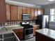 A kitchen features wooden cabinets, stainless steel appliances, and an island counter at 1527 Haywards Heath Ln, Apex, NC 27502